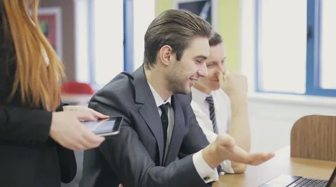 Office workers looking at laptop and discussing Stock Footage 59853008