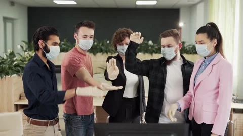 Office workers in protective masks and gloves fold their arms in a pyramid Stock Footage 131524664