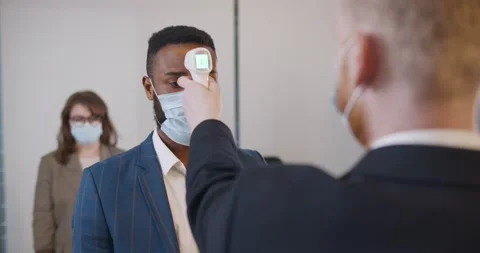 Office workers in safety mask checked with non-contact thermometer during Stock Footage 148231038
