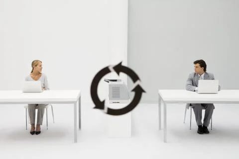 Office workers sitting with laptops, looking at each other, printer and Foto stock