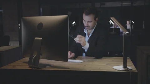 Office workers sitting at workplaces and developing projects late at night Stock Footage 125683320