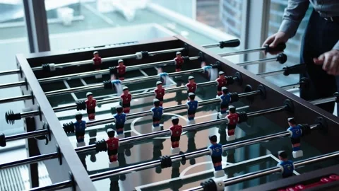 Office workers take a break from routine work with a table game of football Stock Footage 195120531