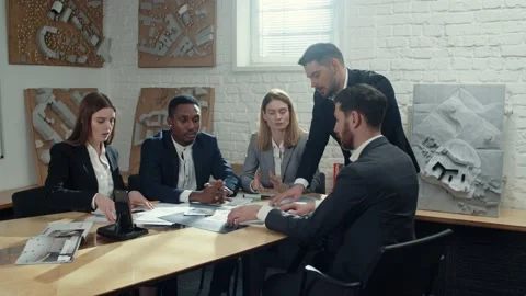 Office workers talking to each others, looking at papers, discussing project Stock Footage 189036773