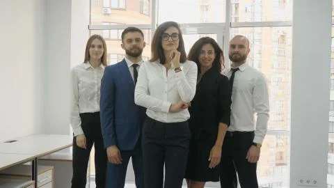 Office workers, two young men and three young women lined up in a triangle Foto stock