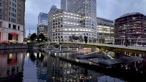 Office workers walking over the North Dock Footbridge at Canary Wharf, London Stock Footage 314362611
