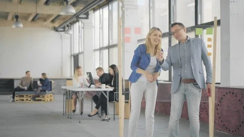 Office workflow. Colleagues discuss business tasks with a Glass Whiteboard Stock Footage 108869140