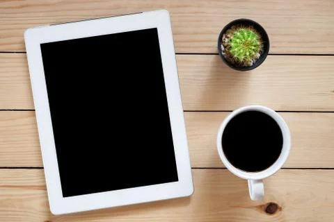 Office workplace with blank screen tablet and coffee cup on rustic wood table Stock Photos