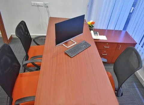 Office workplace with desktop and computer on wood table with three chairs, C Stock Photos