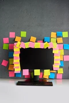 Office workplace with desktop pc full of blank colorful sticky notes Stock Photos