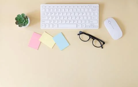 Office workplace table with computer keyboard, mouse, glasses, stickers and p Stock Photos