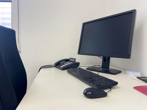 Office workspace featuring a modern computer monitor, keyboard, and telepho.. Stock Photos