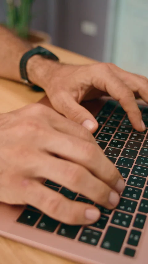 In an office workspace, hands are actively typing on a laptop keyboard, engaged 스톡 동영상 276340843