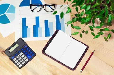 Office workstation with computer, graphs, calculator and glasses. Top view Stock Photos