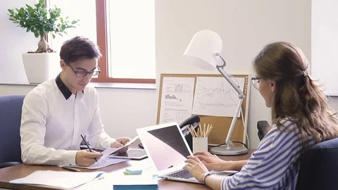 In office young man asks question on documents of woman opposite. Stock Footage 81910225
