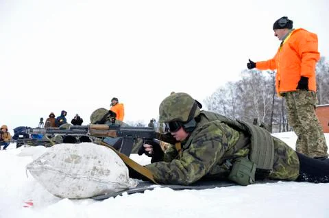 Officer-instructor teaching soldiers, conscripts, firing with Kalashnikov rifle Stock Photos