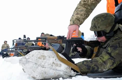 Officer-instructor teaching soldiers, conscripts, firing with Kalashnikov rifle Stock Photos