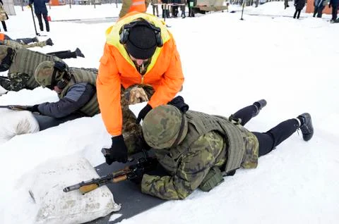 Officer-instructor teaching soldiers, conscripts, firing with Kalashnikov rifle Fotos de archivo