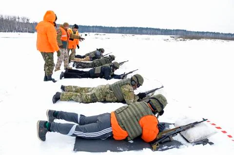 Officer-instructor teaching soldiers, conscripts, firing with Kalashnikov rifle Stock Photos