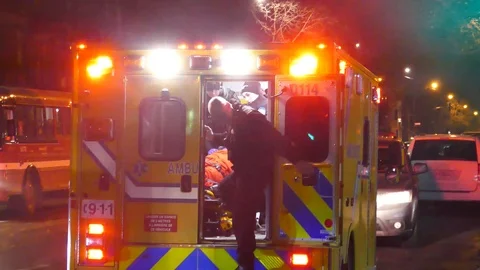 Officer joining victim in ambulance Stock Footage 102000842