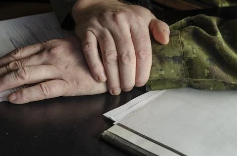 Officer's hands, document folder on black desk in close-up. A middle-aged man Stock Photos