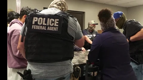 Officers process illegal workers at factory following a search warrant operation Stock Footage 334177027
