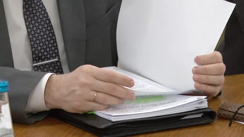An official or businessman examines documents. Stock Footage 248719232