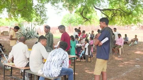 Officials processing documents with villagers in rural India Stock Footage 328568670