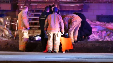 Offiers, firefighters and paramedic working on victim Stock Footage 105197491