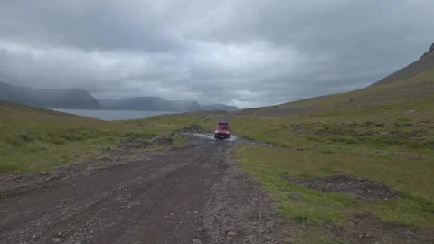 Offroad 4x4 car crossing shallow brook on Svalvogaviti Road, Westfjords Iceland Stock Footage 345312330