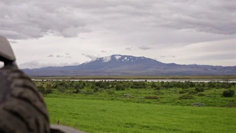 Offroad buggy parked in green valley with mountain backdrop Stock Footage 319270561