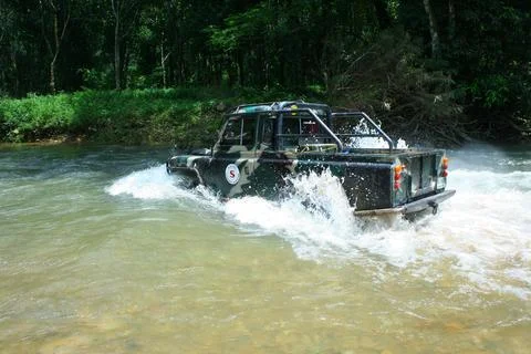 Offroad car crossing river Stock Photos