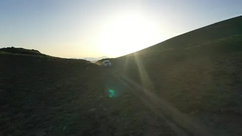 Offroad vehicle driving on mountains at sunset in aerial view Stock Footage 294166754