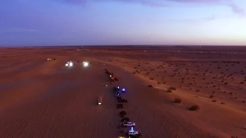 Offroad vehicles racing during dusk in the desert Stock Footage 99158590