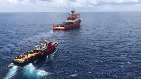 Offshore crew boat performing cargo operations with oil rig crane Stock Footage 143125513
