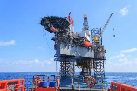 Offshore Jack Up Drilling Rig Over The Production Platform in The Middle of T