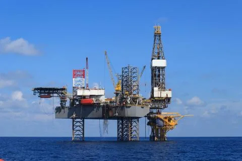 Offshore Jack Up Drilling Rig Over The Production Platform in The Middle of T