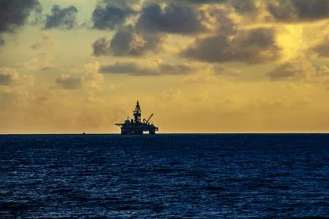 Offshore oil and rig platform in the sunset or sunrise time. Stock Photos