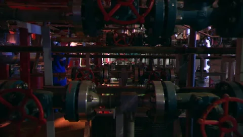 An offshore oil platform worker with a flashlight inspects the platform units. Stock Footage 263052499
