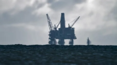 Offshore oil rig floating in the ocean with industrial cranes and wavese Stock Footage 301788745