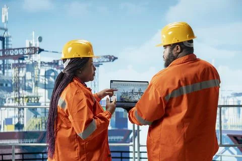 Offshore platform engineers use laptop software to monitor equipment performance Stock Photos