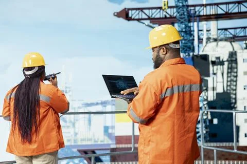 Offshore platform specialists using artificial intelligence tech on device Stock Photos