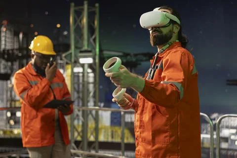 Offshore platform worker using virtual reality technology late at night Stock Photos