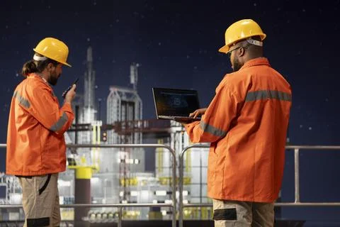 Offshore sea platform engineers use artificial intelligence software on laptop Stock Photos