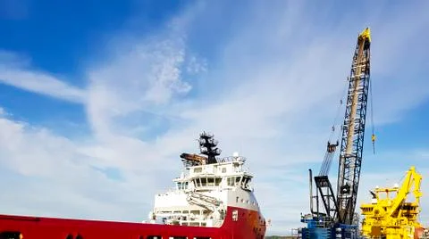 Offshore supply vessel loading cargo, supplies and bunkers in port Stock Photos