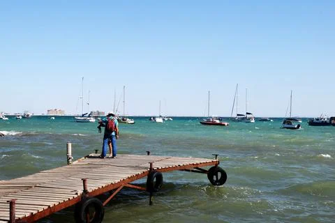 Offshore, there are many different private yachts anchored. Two, a man and a Photos