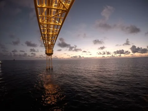 Offshore time lapse sunrise with crew boat moving around flare Stock Footage 87499996