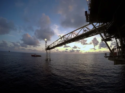 Offshore time lapse sunrise with crew boat moving around flare Stock Footage 87500353