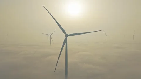 Offshore wind farm generating renewable energy above the fog Stockbeeldmateriaal 330421168