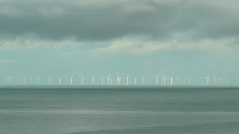 An offshore wind farm on the horizon with very little breeze Stock Footage 218637185