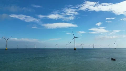 Offshore wind farm with multiple turbines rotating in the ocean under blue sky Stock Footage 342091013